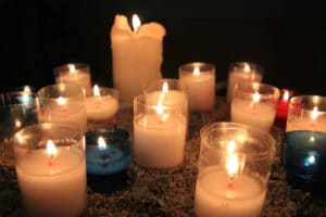 Image of lit candles in a church with dark background