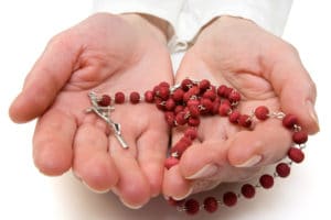 Image of person holding Rosary Beads